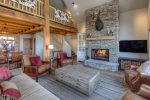 Amazing open living room with floor to ceiling stone wood burning fireplace, amazing views, and plenty of seating